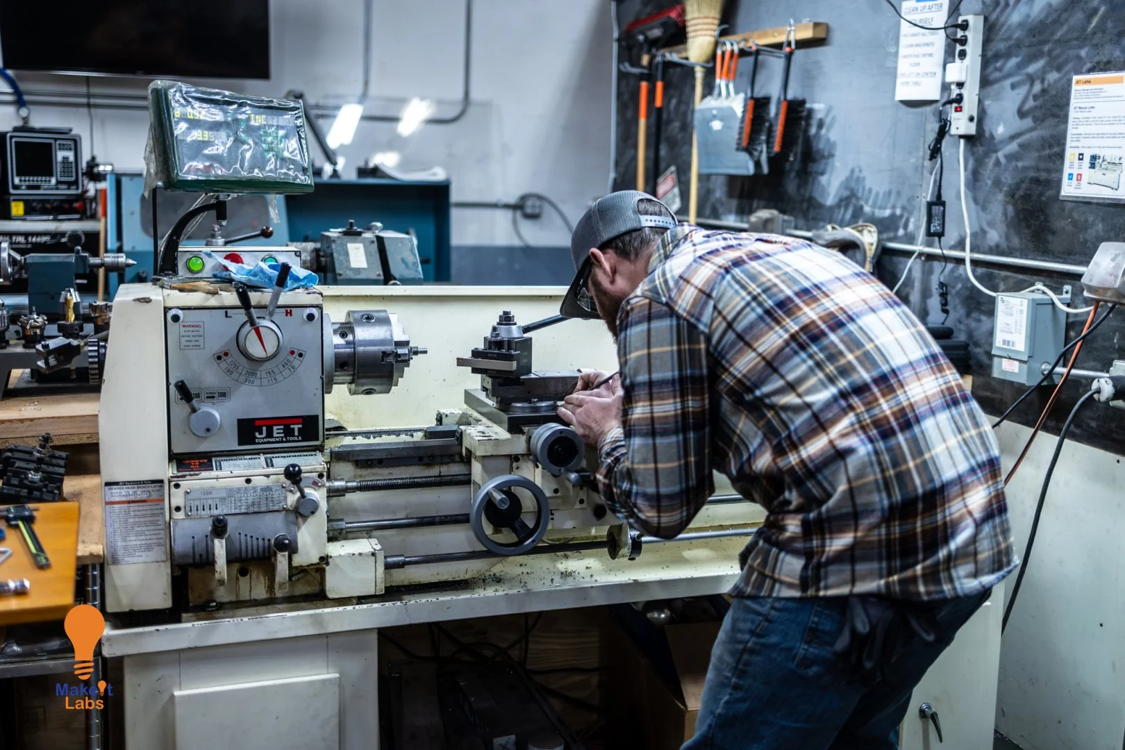 Machinist running a lathe in the FJM Manufacturing shop