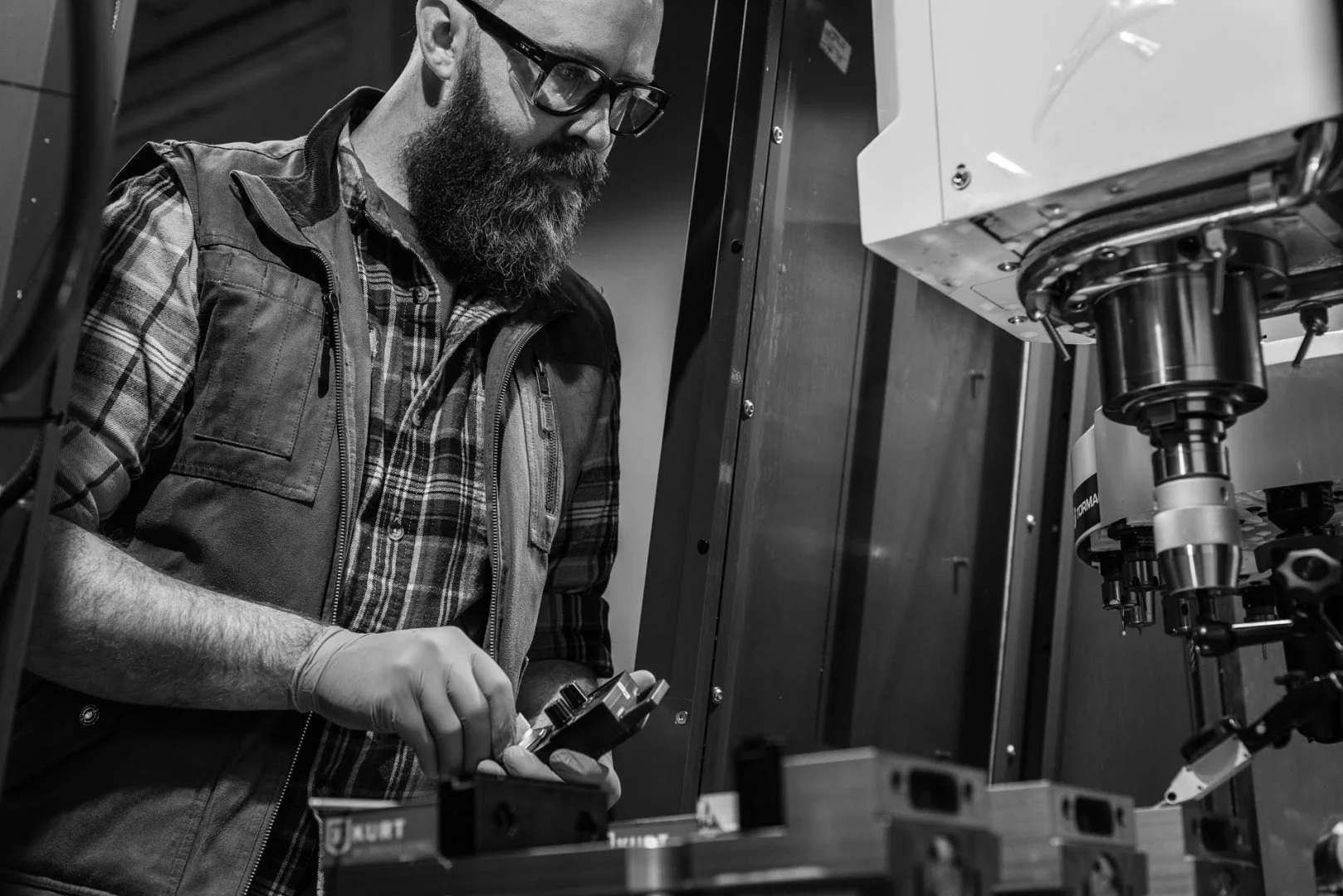 Machinist working at a vertical mill in the FJM Manufacturing shop in Nashua, New Hampshire
