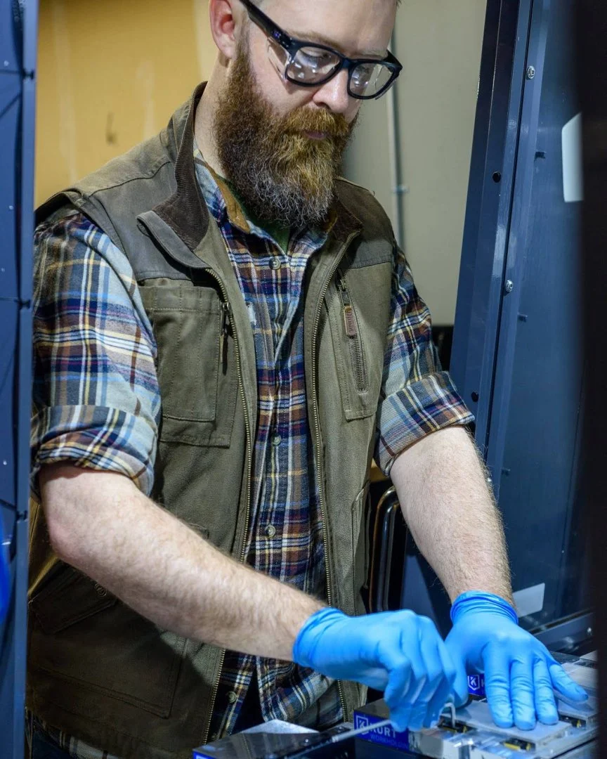 Frederick John Martin loading a fixture plate into a Kurt vise on the mill at FJM Manufacturing